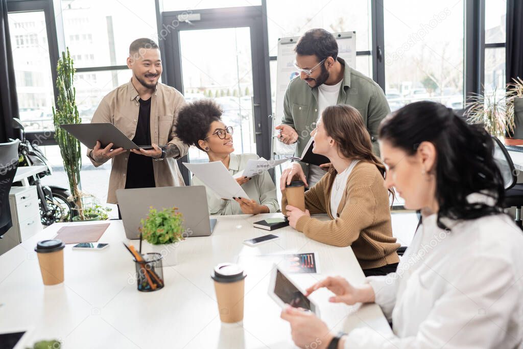 Equipo colaborando y compartiendo ideas en una mesa de trabajo
