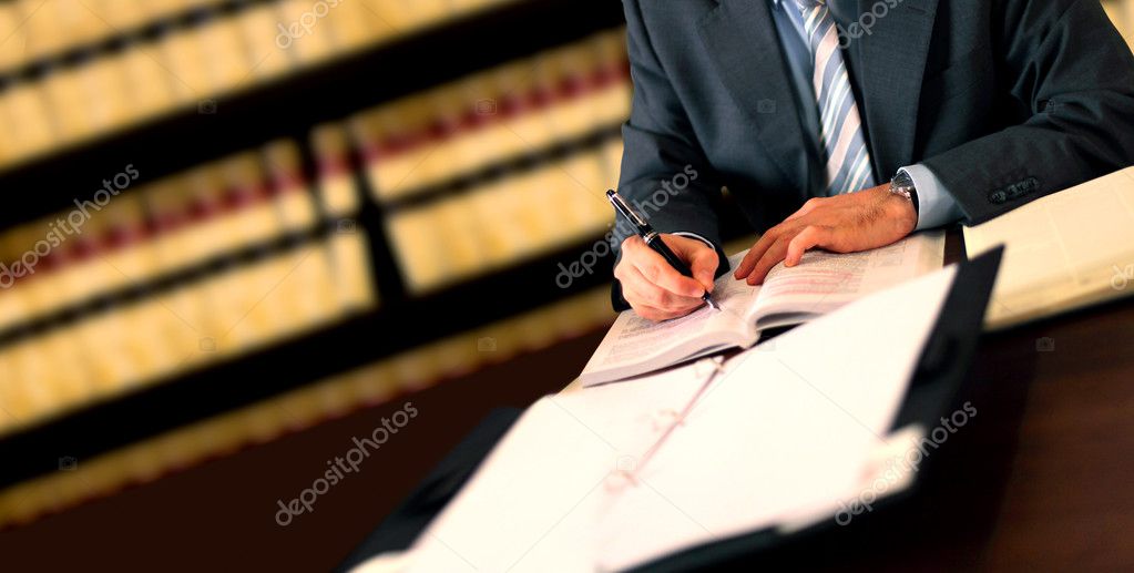 Abogado revisando documentos legales en una oficina con estanterías de libros